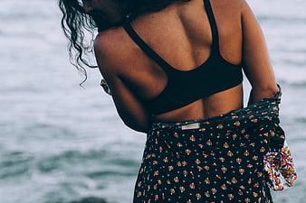 Woman in Black Top and Floral Skirt by the Ocean