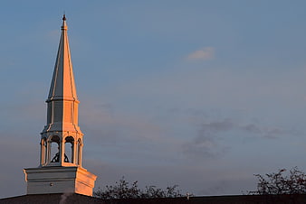 White church steeple illuminated by golden sunrise light