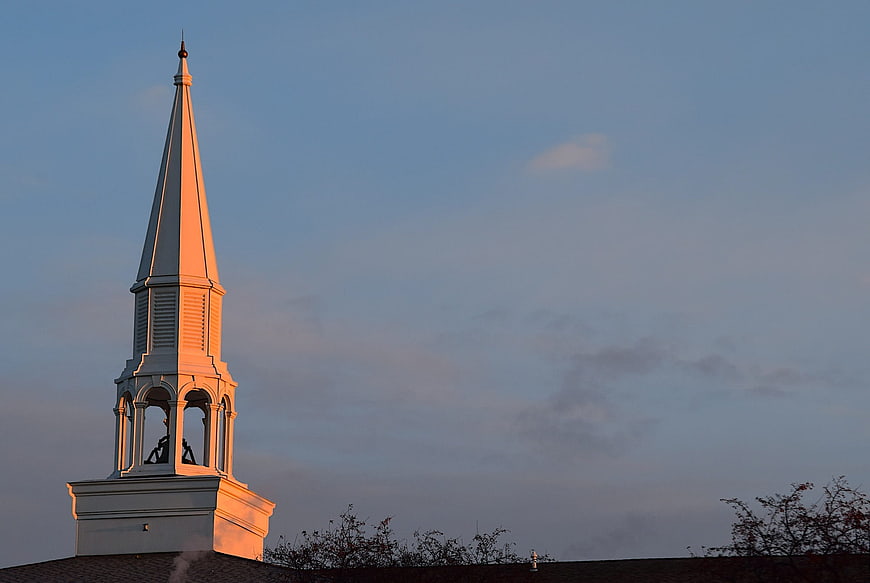 White church steeple illuminated by golden sunrise light