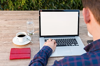 Man Typing on Laptop with Coffee and Wallet