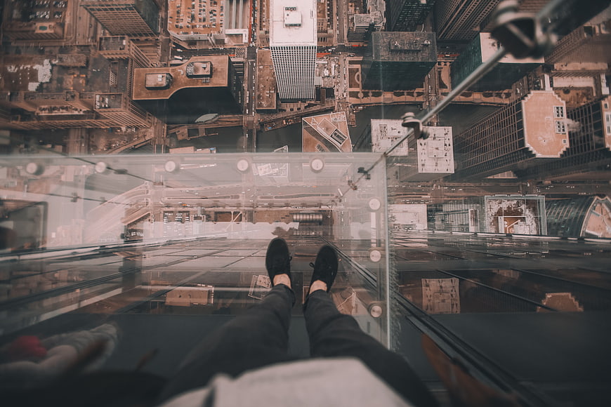 First-person view standing on glass floor of skyscraper