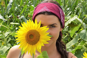 Young Woman with Sunflower in Summer Field