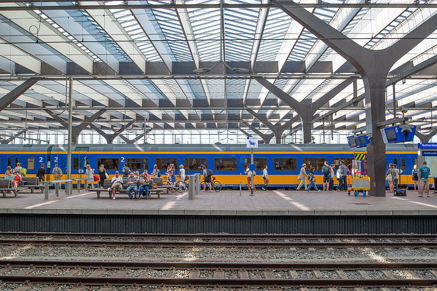 Busy Train Station Platform with Blue and Yellow Train