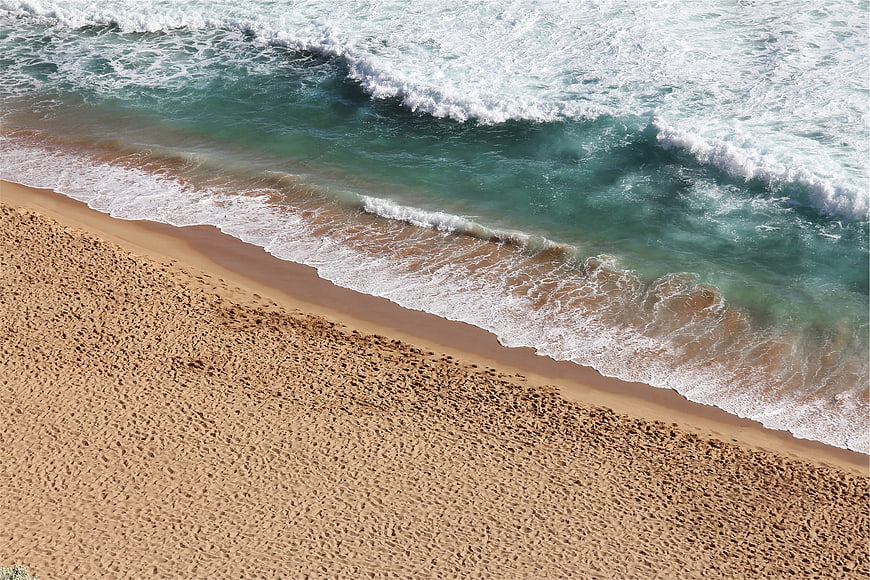 Aerial View of Turquoise Waves Crashing on Sandy Beach