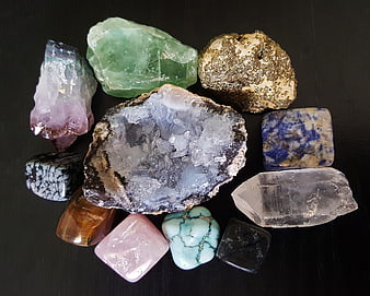 Collection of raw crystals and gemstones on black background