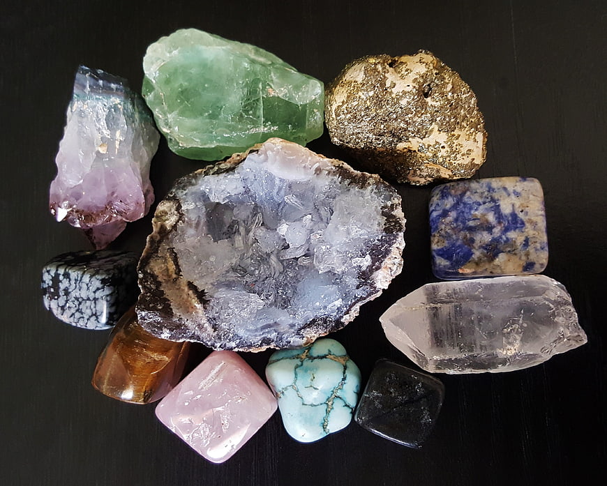 Collection of raw crystals and gemstones on black background