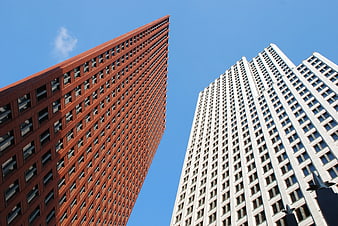 Low angle view of red and white skyscrapers against blue sky