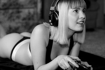 Young woman with headphones and game controller lying down