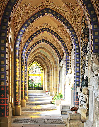 Ornate Neo-Gothic Crypt Hall with Stained Glass and Sunlight