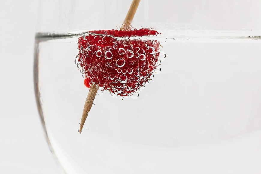 Red Raspberry Floating in Clear Water with Bubbles