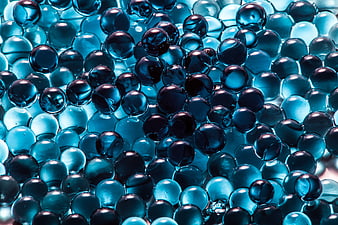 Close-up of glossy blue glass marbles and pebbles