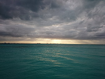 Dramatic Sunbeams Breaking Through Storm Clouds Over Ocean