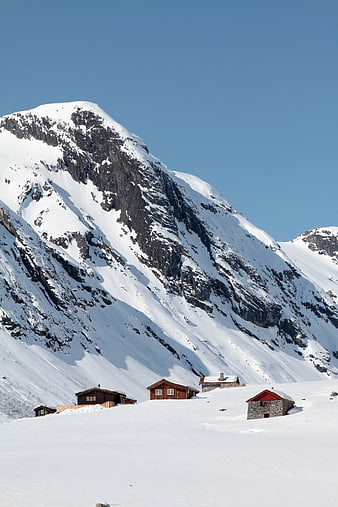 Snowy Mountain Cabins Under Clear Blue Sky