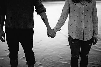 Couple Holding Hands on Sandy Beach in Black and White