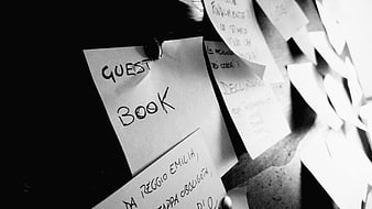 Black and white close-up of handwritten guest book notes on a board