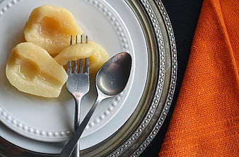 Poached Pears on White Plate with Silver Cutlery