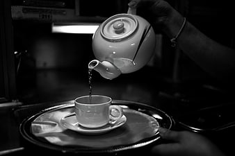 Black and white photo of tea being poured from a teapot