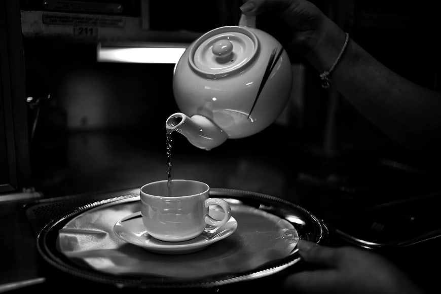 Black and white photo of tea being poured from a teapot
