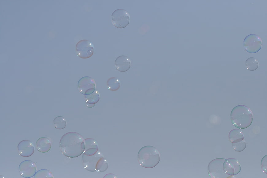 Soap Bubbles Floating Against a Soft Blue Sky Background
