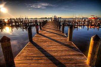 Wooden Dock Leading to Marina at Sunset with Boats