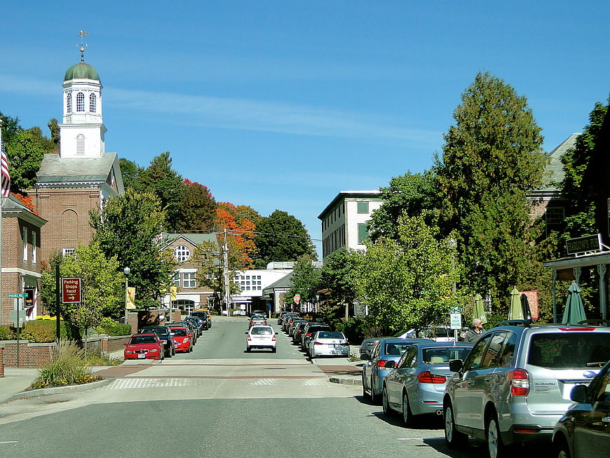 Quaint New England Town Street With Historic Church And Parked Cars