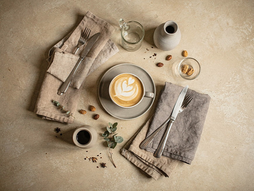 Flat Lay of Latte Art Coffee with Nuts and Cutlery