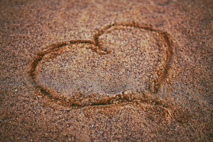 Heart drawn in sand texture close up