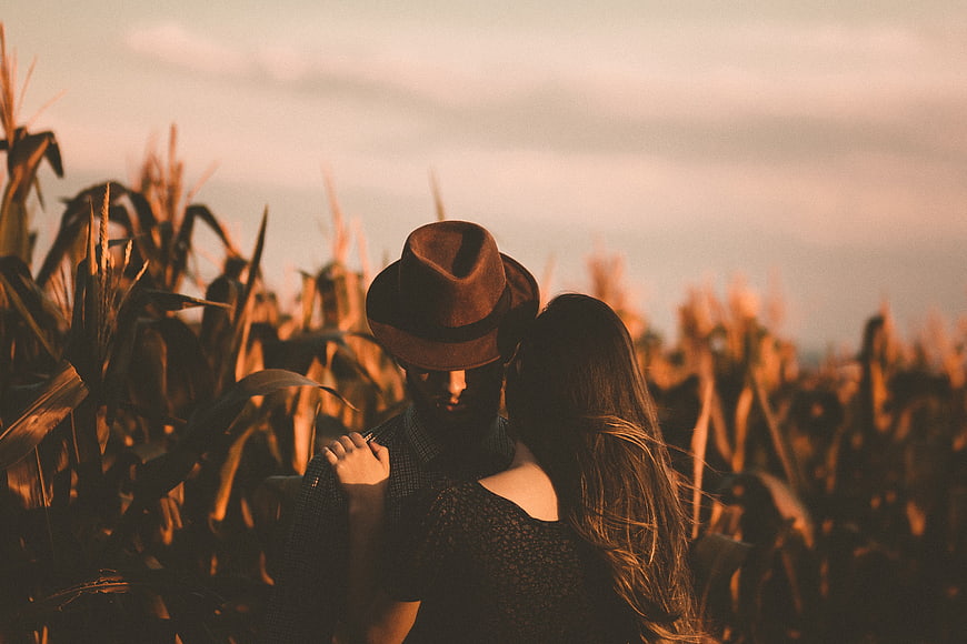 Romantic couple embracing in cornfield at sunset