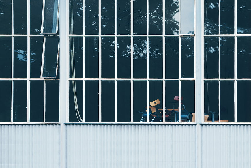 Modern building facade with grid windows and interior chairs