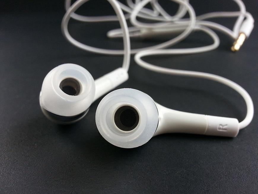 White Wired Earbuds on Dark Surface