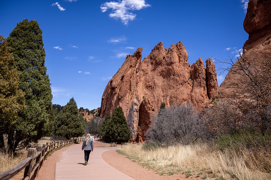 Woman hiking on path near red rock formations