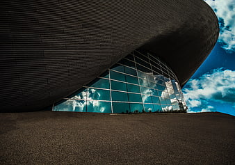 Modern Curved Architecture with Glass Facade and Blue Sky