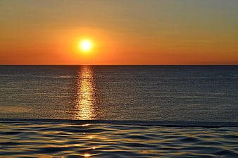 Sunset over ocean with infinity pool reflection