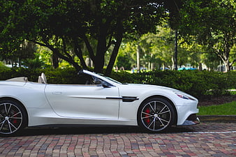 White luxury convertible sports car parked on brick driveway
