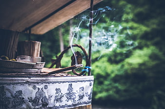 Burning incense stick on traditional altar in forest