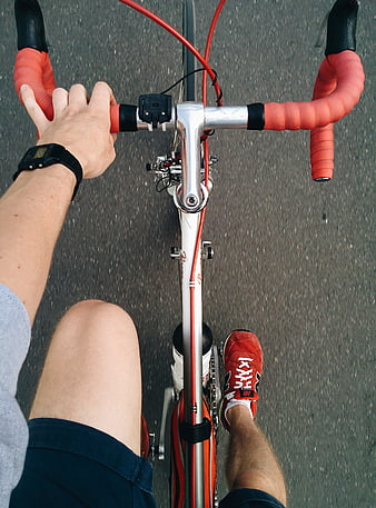 First-person view of cyclist riding road bike on asphalt