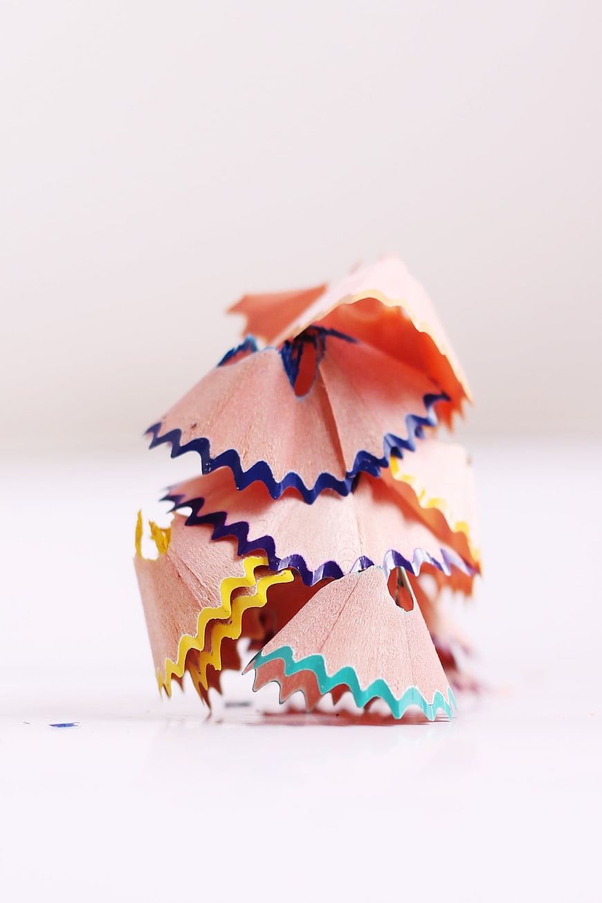 Stack of colorful pencil shavings on white background