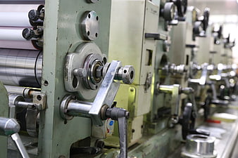 Close-up of industrial offset printing machine rollers and mechanical components
