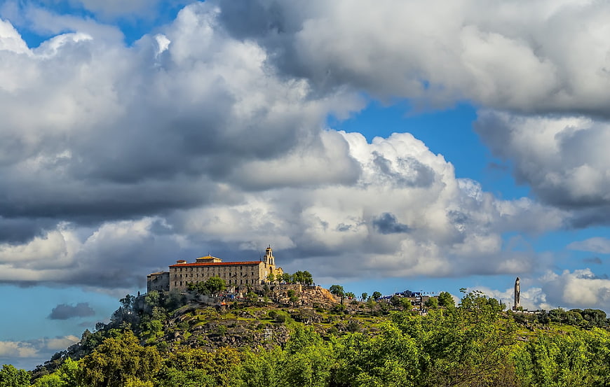 Historic monastery on a hilltop under dramatic cloudy sky