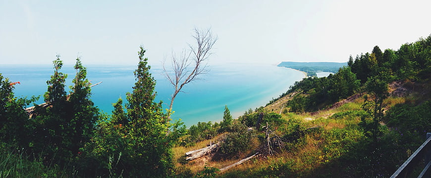 Panoramic View of Turquoise Lake and Forested Cliffside