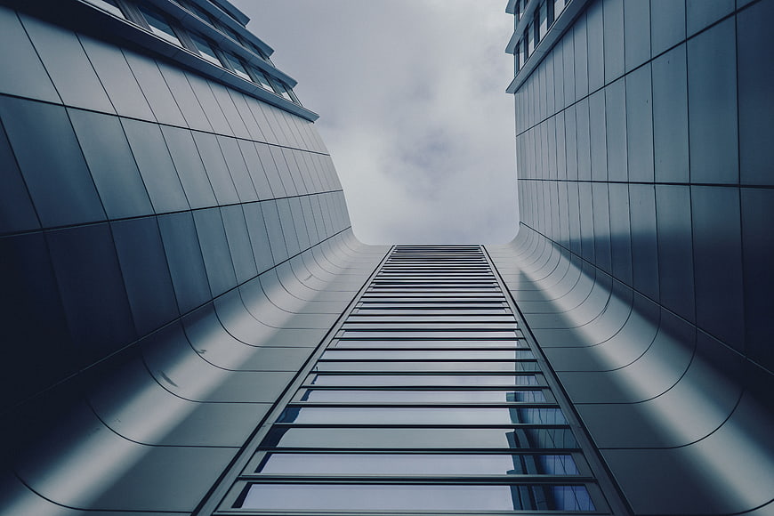 Low angle view of modern skyscraper architecture against cloudy sky