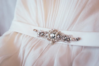 Close-up of elegant pearl and crystal bridal belt on white dress