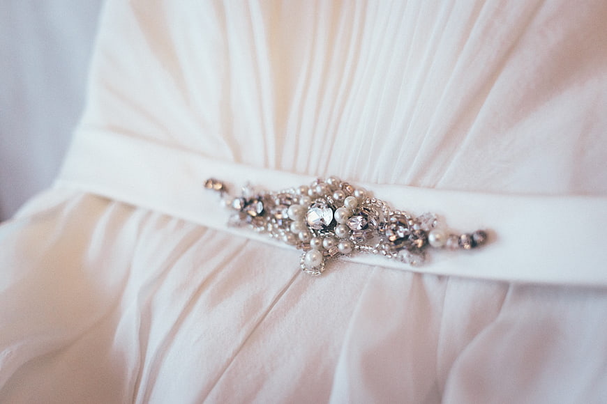 Close-up of elegant pearl and crystal bridal belt on white dress