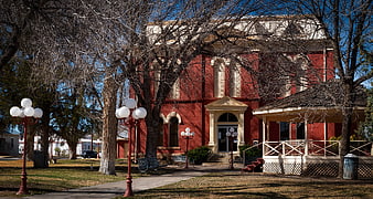 Red Brick Historic Building with Porch and Trees