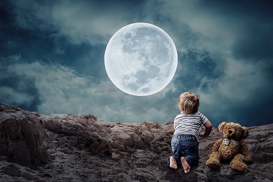 Toddler crawling on rocky terrain with teddy bear under giant moon