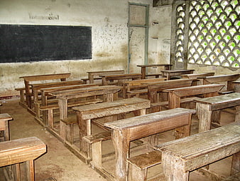 Empty rustic classroom with wooden desks and chalkboard