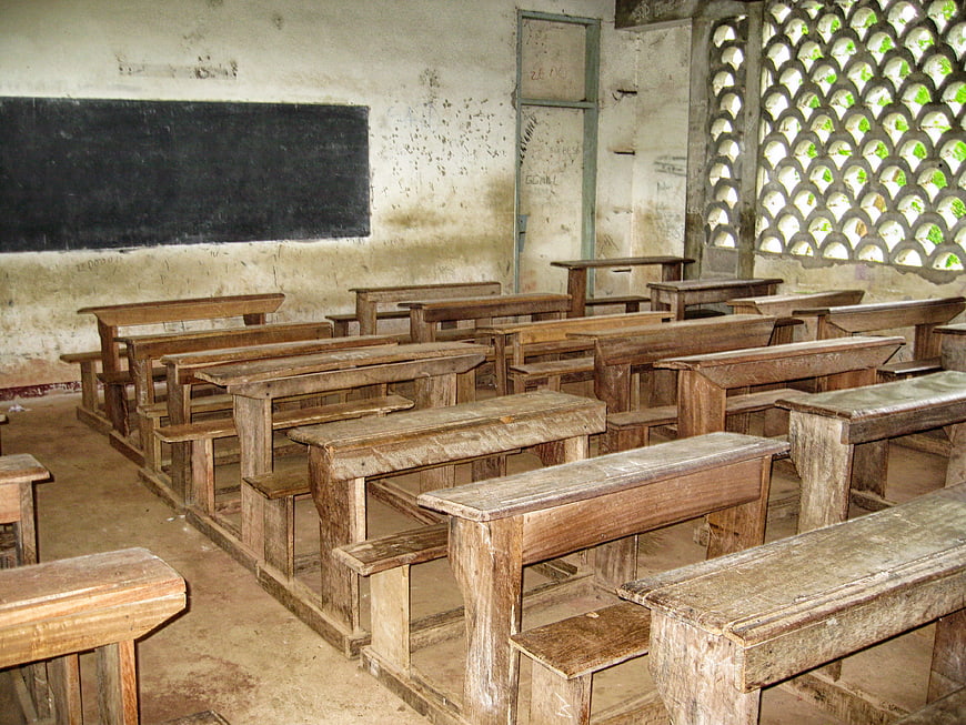 Empty rustic classroom with wooden desks and chalkboard