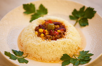 Chili con Carne Served Over Mounded White Rice with Parsley Garnish