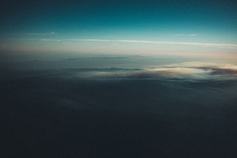 Aerial View of Misty Mountains at Dusk with Soft Sunset Glow