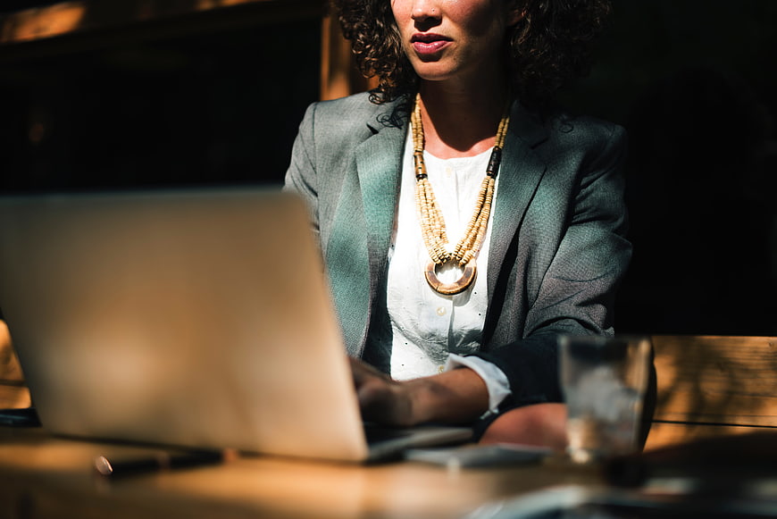 Professional Woman Working On Laptop In Dimly Lit Office